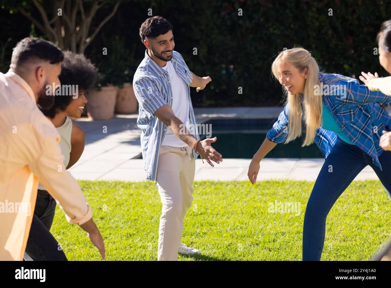 Im Freien spielen, eine Gruppe junger Freunde, die die Zeit zusammen auf dem Gras genießen Stockfoto
