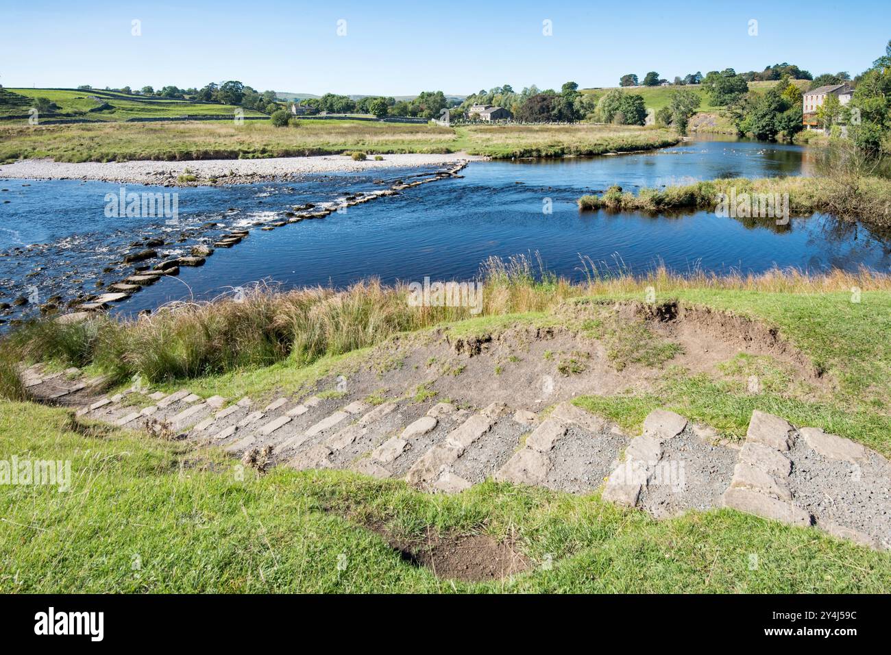 Trittsteine, die den Zugang über den River Wharfe in Richtung Linton Church ermöglichen, wenn der Wasserstand nicht zu hoch ist. Stockfoto