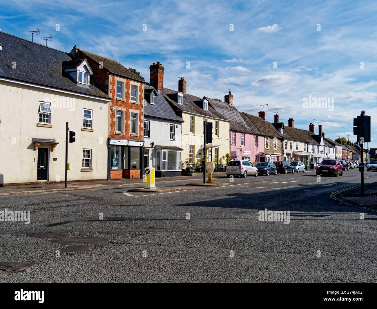 Swindon Street mit kleinen Unternehmen und Wohnhäusern an einer Ampelkreuzung mit einer überquerenden Insel in Highworth, Swindon, Wiltshire, England Stockfoto