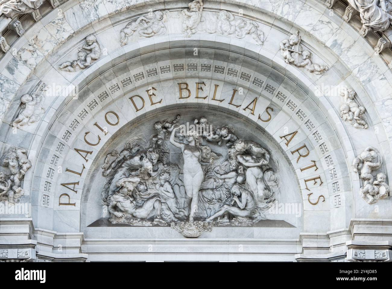 Palacio de Bellas Artes La Armonía Skulptur Mexiko-STADT // MEXIKO-STADT, Mexiko — La Armonía (Harmony), eine allegorische Skulptur, die 1910 vom italienischen Bildhauer Leonardo Bistolfi geschaffen wurde, nimmt die zentrale Position im Giebel des Palacio de Bellas Artes ein. Dieses Werk repräsentiert die Vereinigung verschiedener künstlerischer Disziplinen und spiegelt die Rolle des Gebäudes als wichtigstes kulturelles Zentrum Mexikos wider. Die Skulptur ist Teil des ursprünglichen dekorativen Programms des Palastes, das während der Porfiriato-Ära unter Präsident Porfirio Díaz in Auftrag gegeben wurde. Bistolfis klassische Komposition zeigt die europäischen Künstler Stockfoto