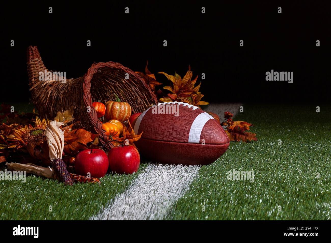 Eine Füllung mit einem Fußball auf einem Rasenfeld mit Streifen und dunklem Hintergrund Stockfoto