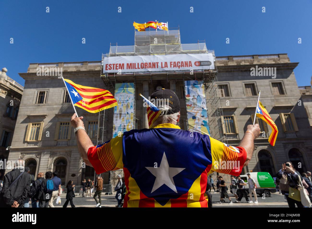 Ein Mann demonstriert und winkt die katalanische Flagge in Barcelona, Spanien. Stockfoto