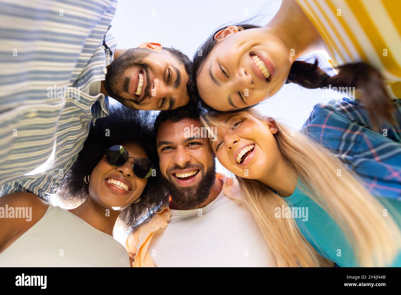 Eine Gruppe junger, vielfältiger Freunde lächelt und blickt in die Kamera herunter und genießt die gemeinsame Zeit Stockfoto