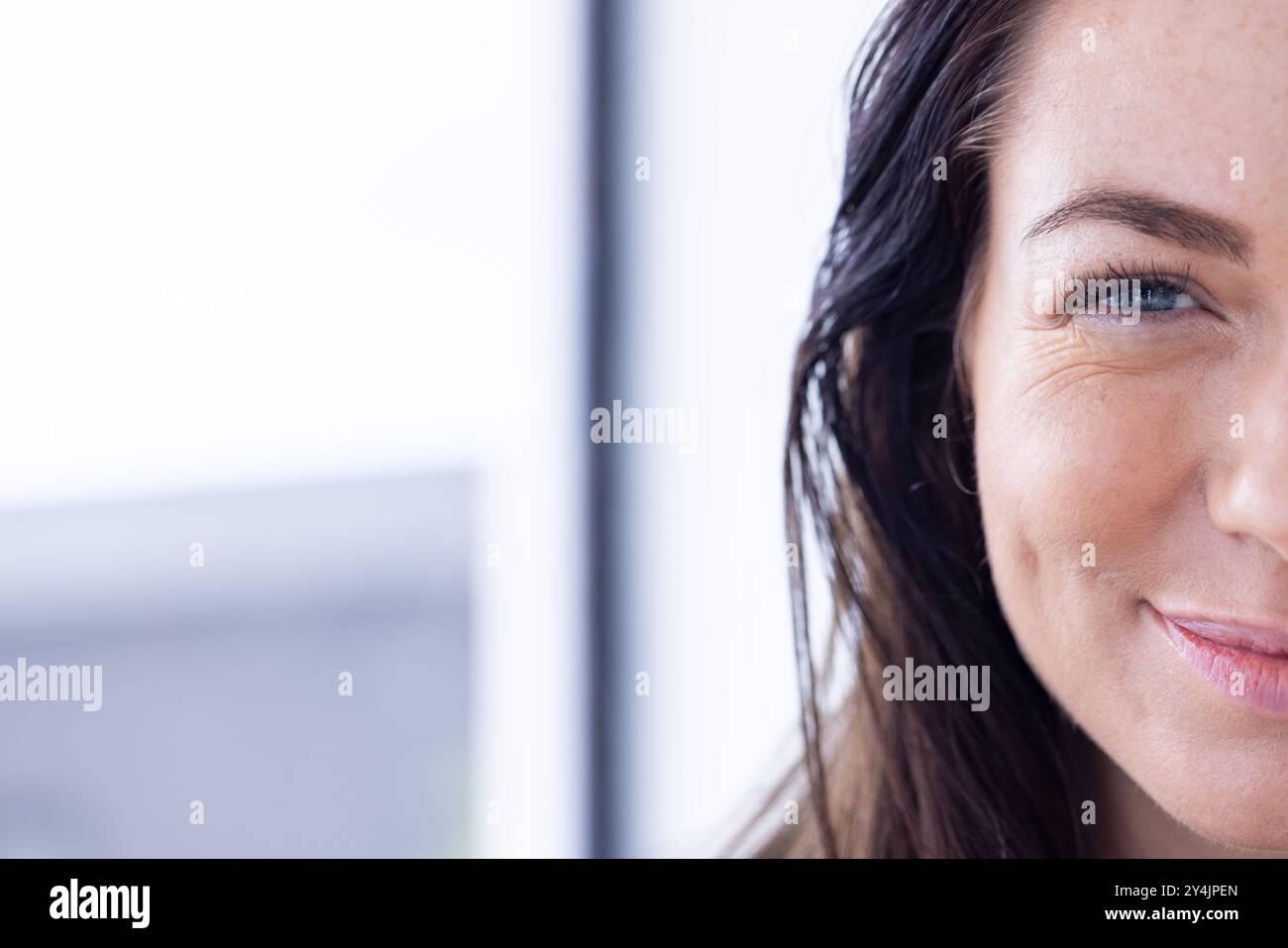 Zu Hause, lächelnde Frau, die die Hälfte ihres Gesichts mit Nahsicht zeigt, Kopierraum Stockfoto