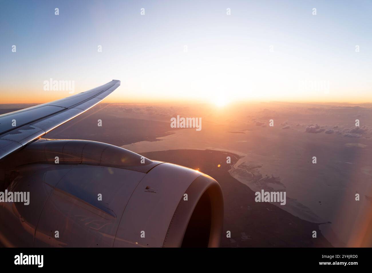 Wingview eines modernen Jet-Flugzeugs im goldenen Abendsonnenlicht über der Nordsee Stockfoto