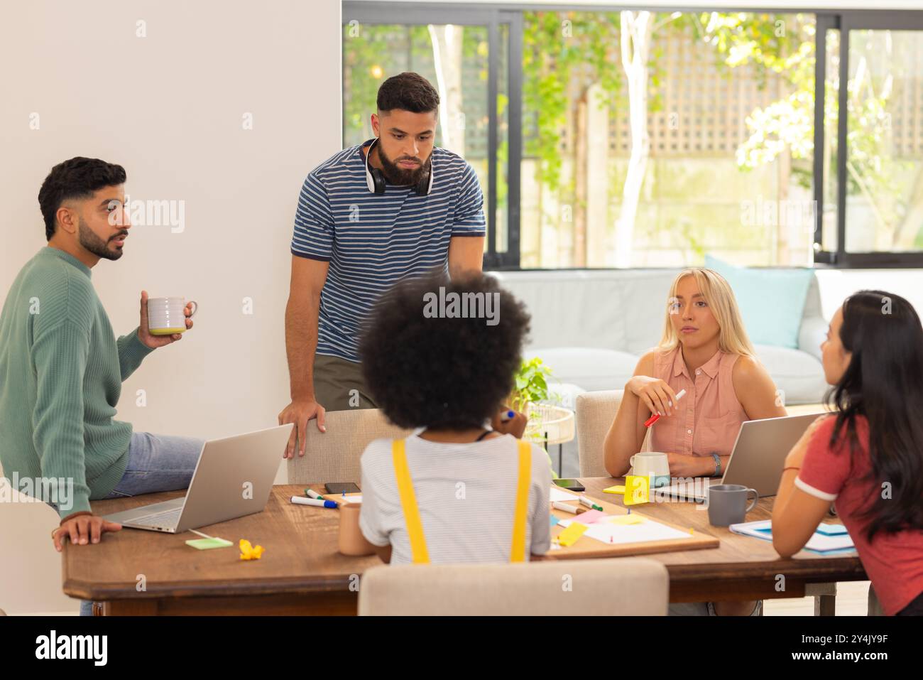 Starten Sie ein Unternehmen, arbeiten Sie an Projekten zusammen, setzen Sie sich mit Ihren Laptops in eine Gruppe von Freunden ein und diskutieren Sie Ideen Stockfoto