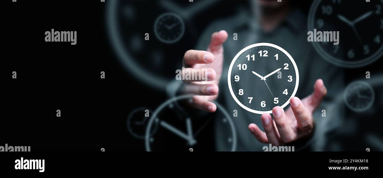 Zeitmanagement-Konzept. Mann mit Uhr in den Händen, die seine Kontrolle repräsentiert und sein Leben, sein Geschäft und seine Arbeit mit Technologie für Produktivität plant Stockfoto