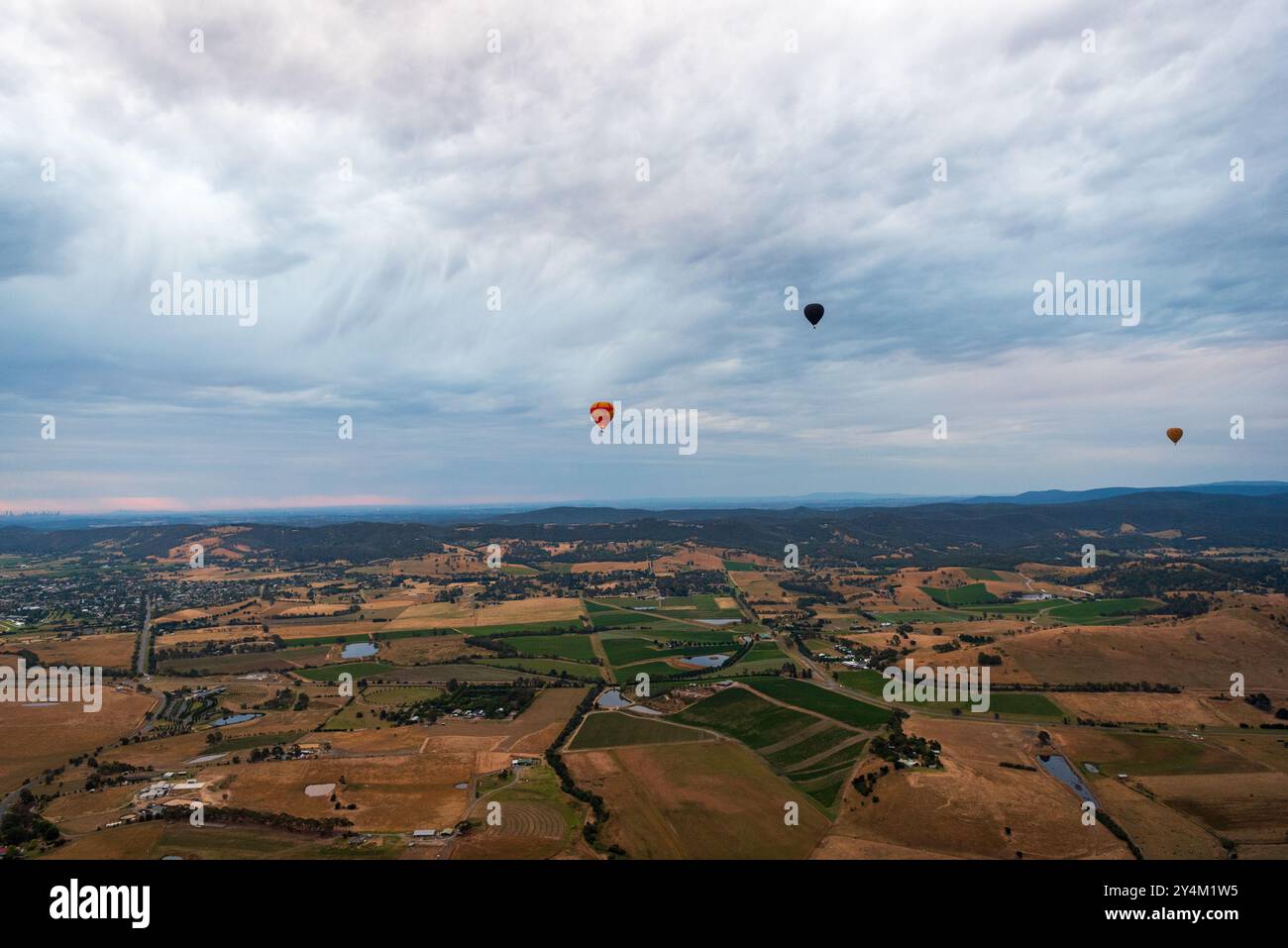 Blick aus der Vogelperspektive auf das Yarra Valley bei Sonnenaufgang (mit mehreren Heißluftballons in Sicht), aufgenommen von der Heißluftballonfahrt, Victoria, Australien Stockfoto