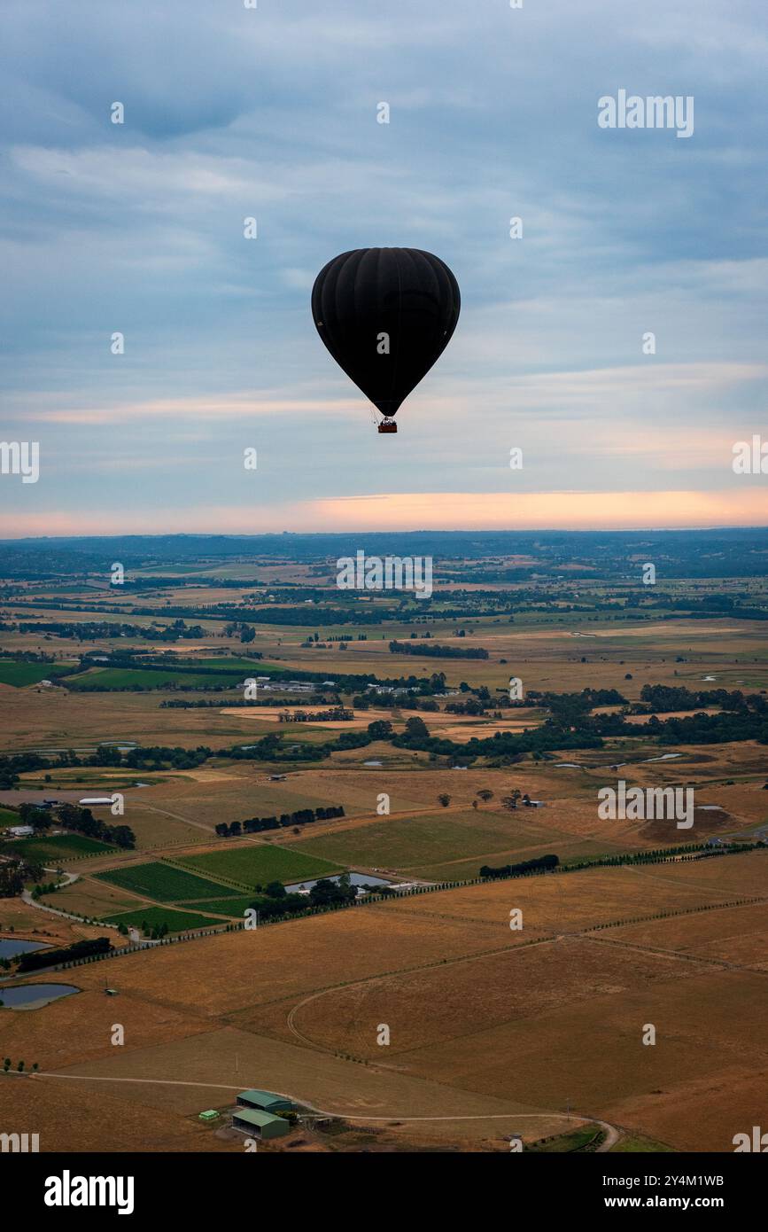 Blick aus der Vogelperspektive auf das Yarra Valley bei Sonnenaufgang (ein Heißluftballon in Sicht), aufgenommen von der Heißluftballonfahrt, Victoria, Australien Stockfoto