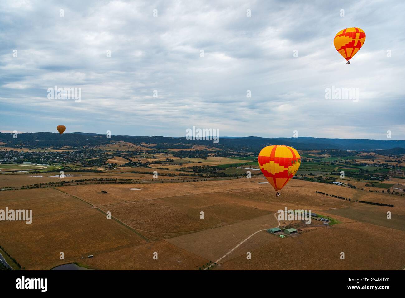 Blick aus der Vogelperspektive auf das Yarra Valley bei Sonnenaufgang (mit mehreren Heißluftballons in Sicht), aufgenommen von der Heißluftballonfahrt, Victoria, Australien Stockfoto