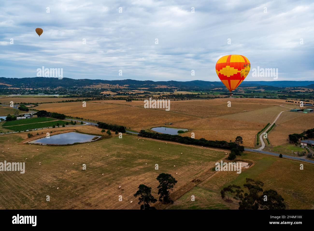Blick aus der Vogelperspektive auf das Yarra Valley bei Sonnenaufgang (mit mehreren Heißluftballons in Sicht), aufgenommen von der Heißluftballonfahrt, Victoria, Australien Stockfoto