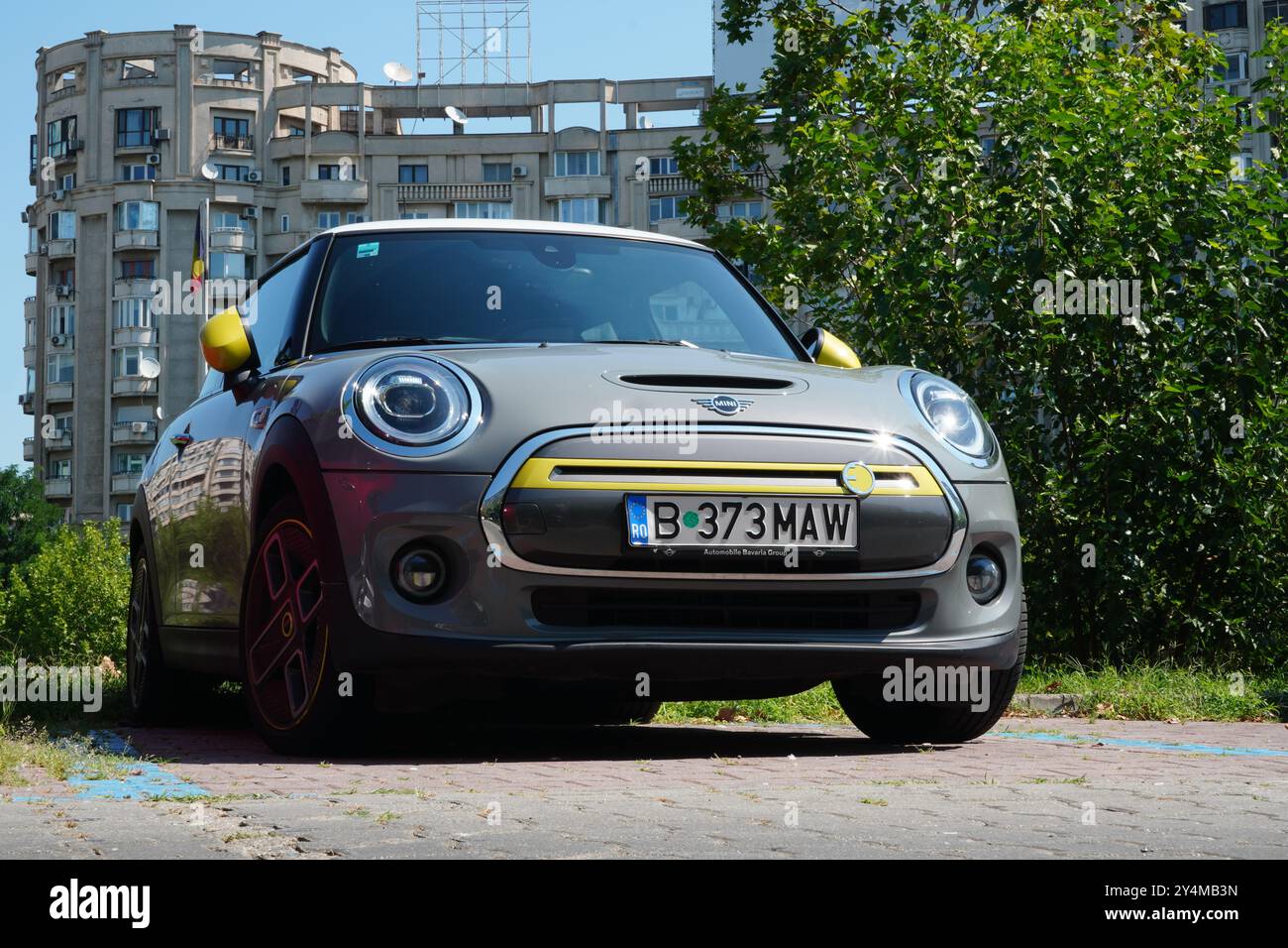 Bukarest, Rumänien - 28. Juli 2024: Mini Cooper SE Elektrograu mit gelbem süßen Auto auf dem Parkplatz in Wohngegend Stockfoto