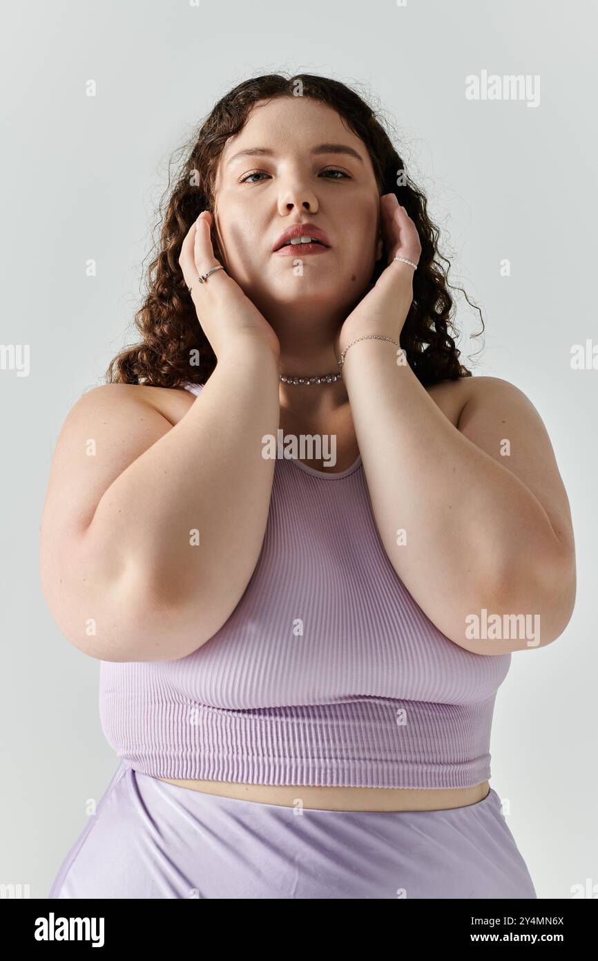 Eine schöne Frau in Übergröße zeigt ihre Eleganz mit einer selbstbewussten Pose und einem sanften Ausdruck. Stockfoto