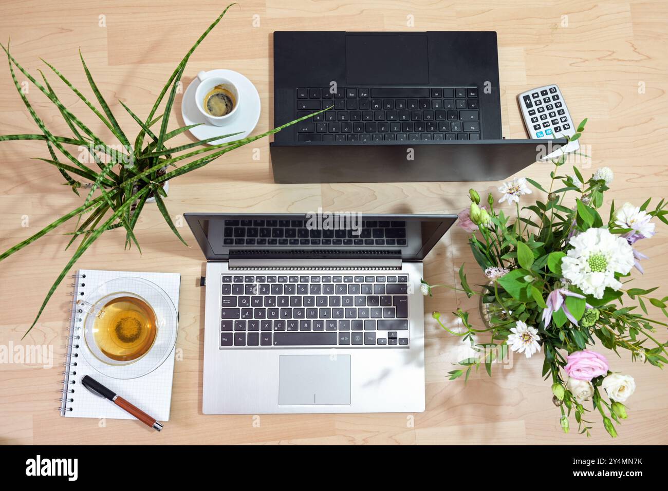 Zwei Laptops in Silber und Schwarz stehen hinten auf einem Holztisch, gemeinsamer männlicher und weiblicher Arbeitsplatz für Geschäftspartner, Team oder Paar, Top-Wettbewerb Stockfoto