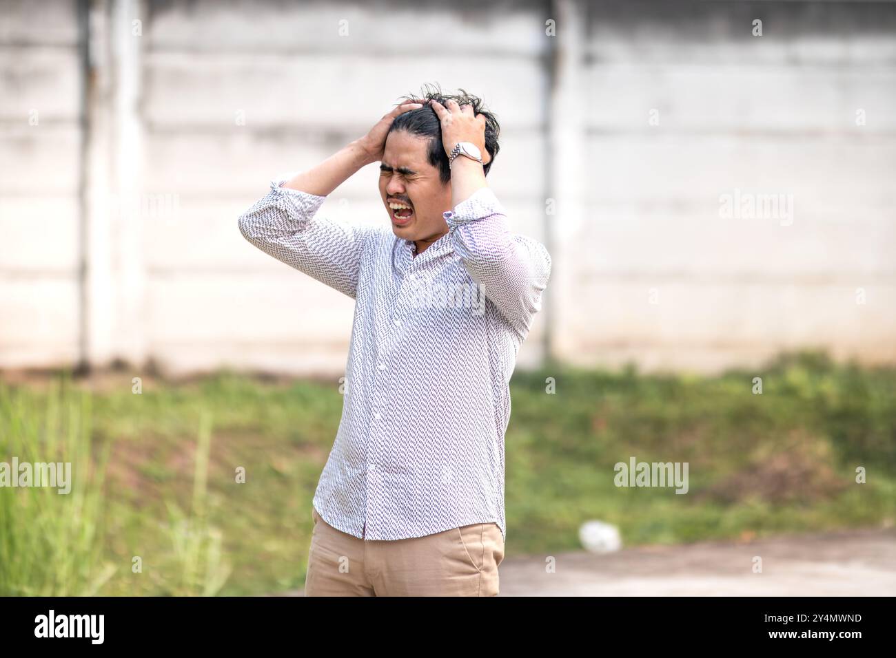Junge Männer brüllen frustriert. Frustriert und in der Lunge geschrien, während er den Kopf hält Stockfoto