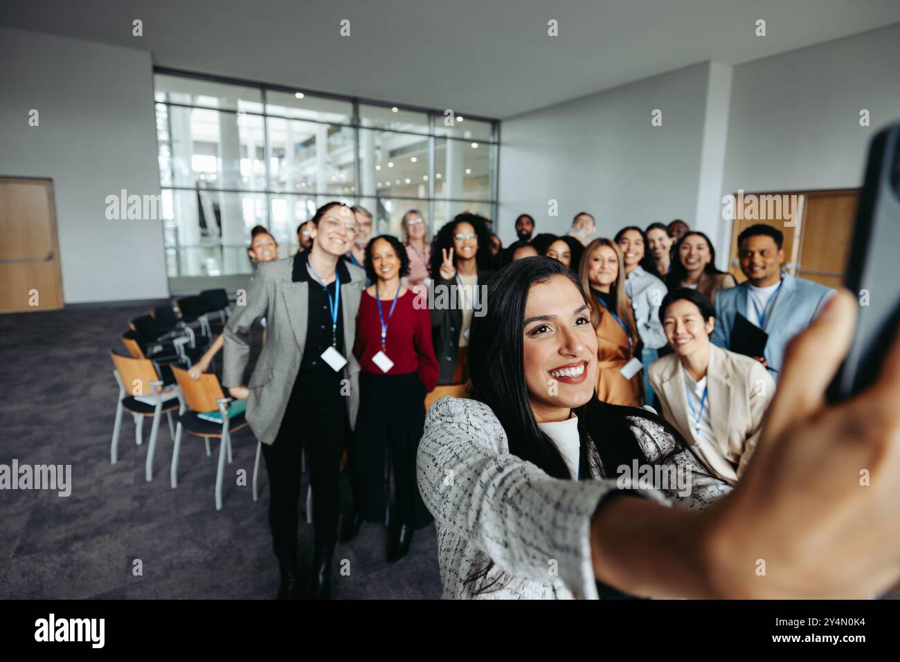 Glücklicher Teamzusammenhalt während eines Seminars, aufgenommen mit einem Selfie in der Gruppe. Kollegen lächeln und genießen die Veranstaltung. Stockfoto
