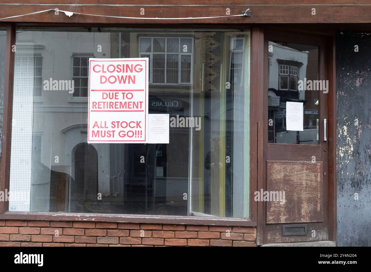 Vorderansicht eines leeren britischen Geschäfts mit einem Schließschild im Fenster. Stockfoto