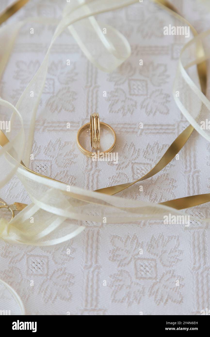 Nahaufnahme von zwei Eheringen mit Hochzeitskränzen. Weichzeichner Stockfoto