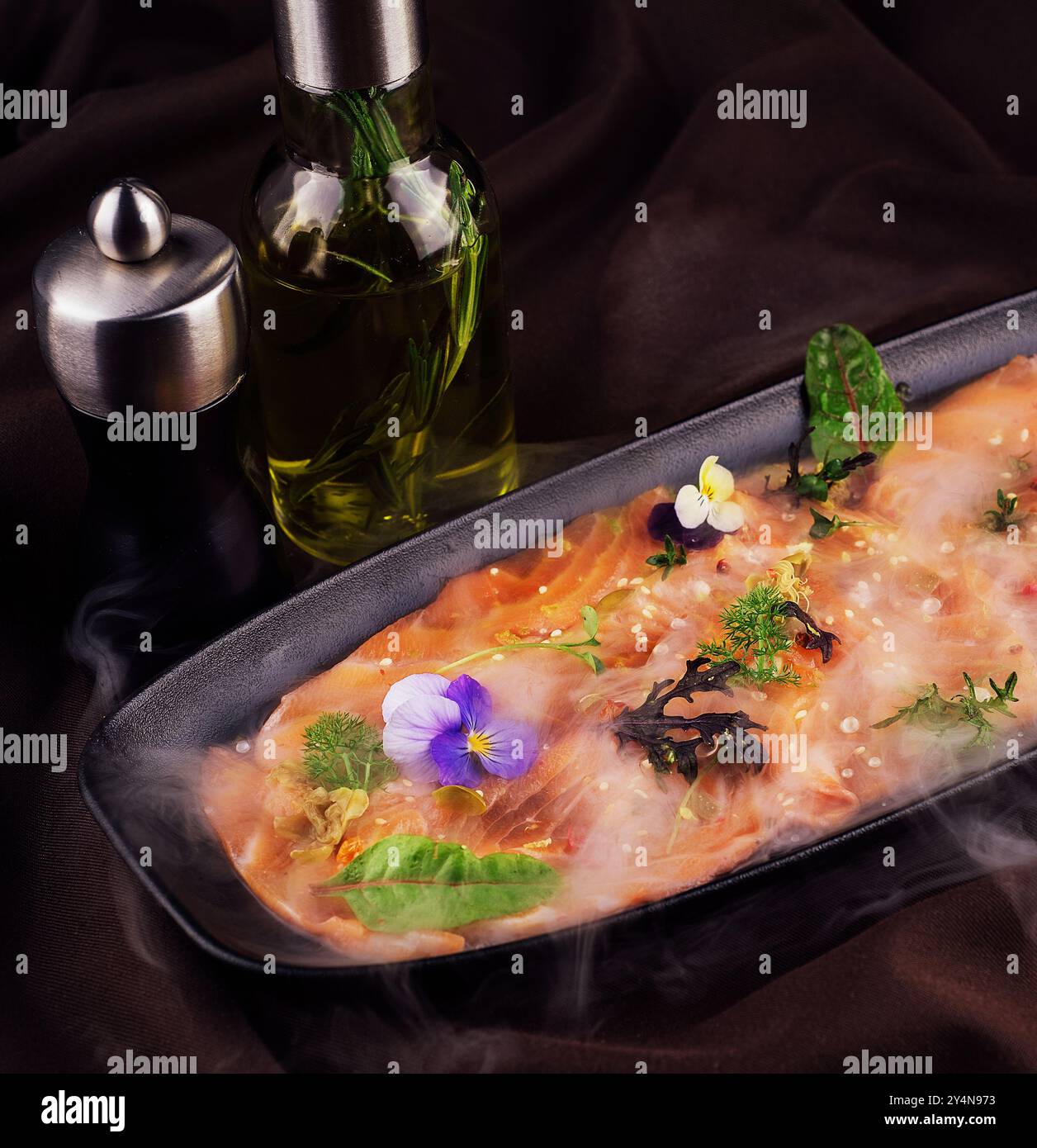 Räucherlachs-Carpaccio und Oktopus mit weißem Rauch von Flüssigstickstoff Stockfoto