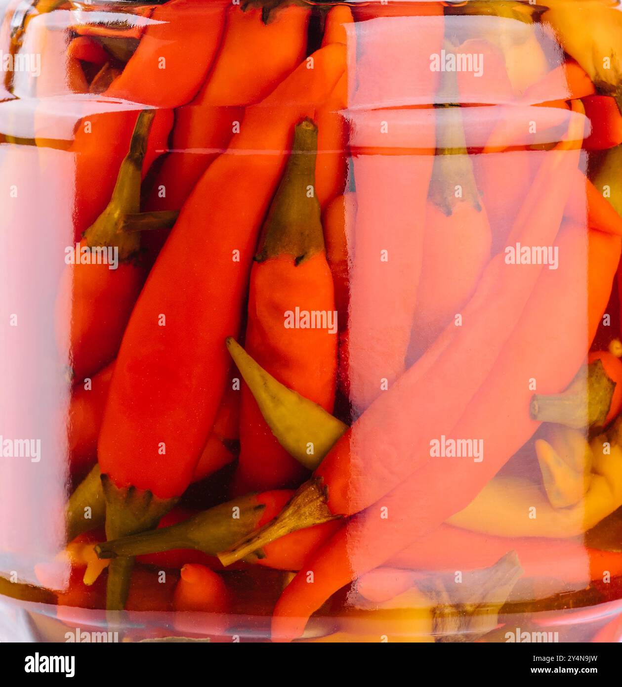 Glasgläser mit eingelegtem Chili-Hintergrund Stockfoto