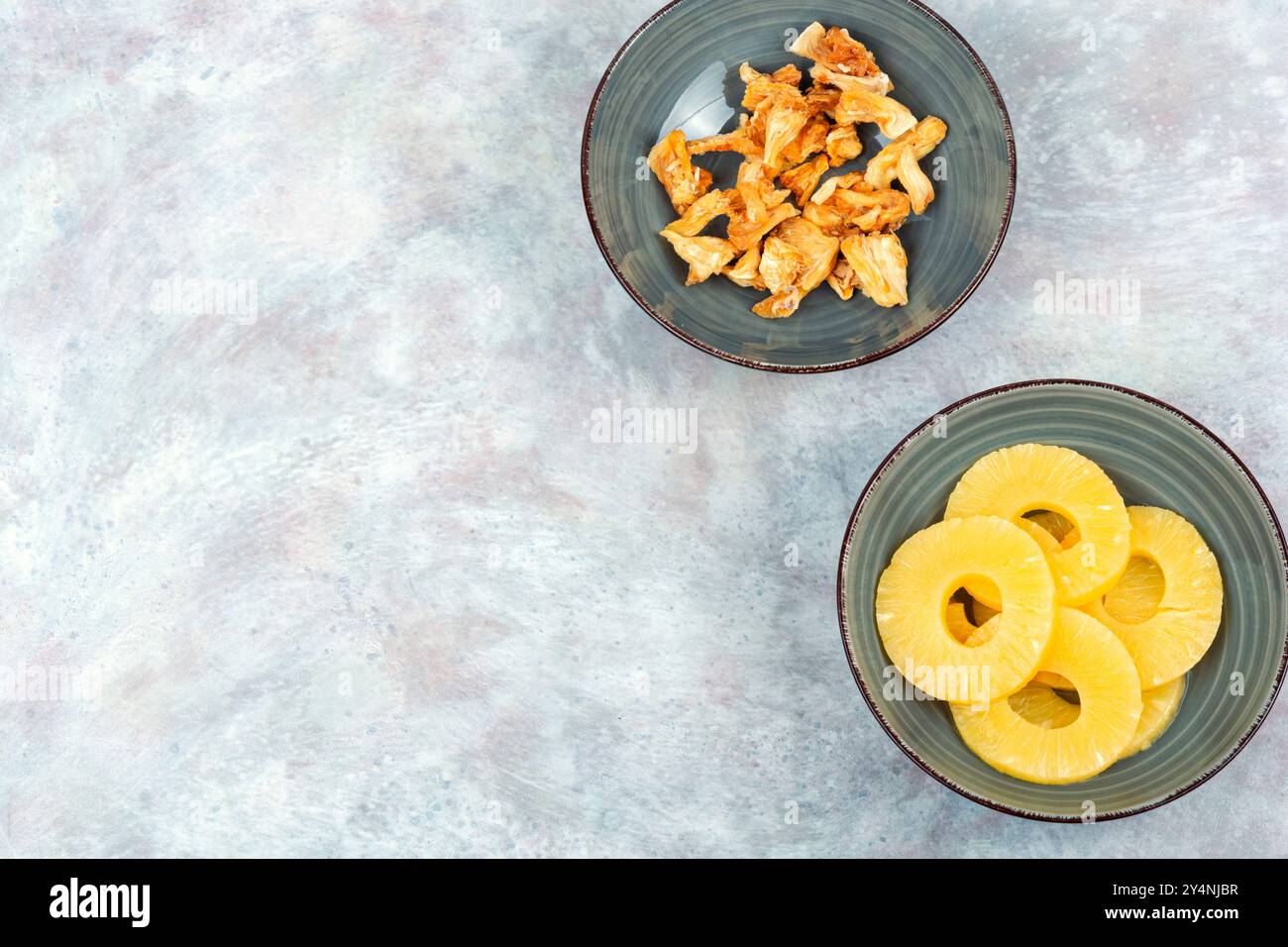 Trockene und frische Ananas in Schüsseln. Süßigkeiten Ananas, kandierte Früchte. Kopierbereich. Stockfoto