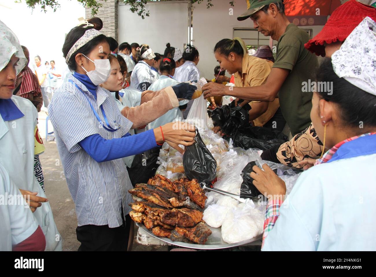 Phnom Penh. September 2024. Arbeiter der Bekleidungsfabrik kaufen am 19. September 2024 in Phnom Penh, Kambodscha Lebensmittel. Kambodscha hat am Donnerstag einen monatlichen Mindestlohn für die Bekleidungs-, Schuh- und Reisewarenindustrie des Landes auf 208 US-Dollar für 2025 festgesetzt, 1,96 Prozent höher als die aktuellen 204 Dollar, sagte der Minister für Arbeit und Berufsbildung Heng Sour. Quelle: Phearum/Xinhua/Alamy Live News Stockfoto