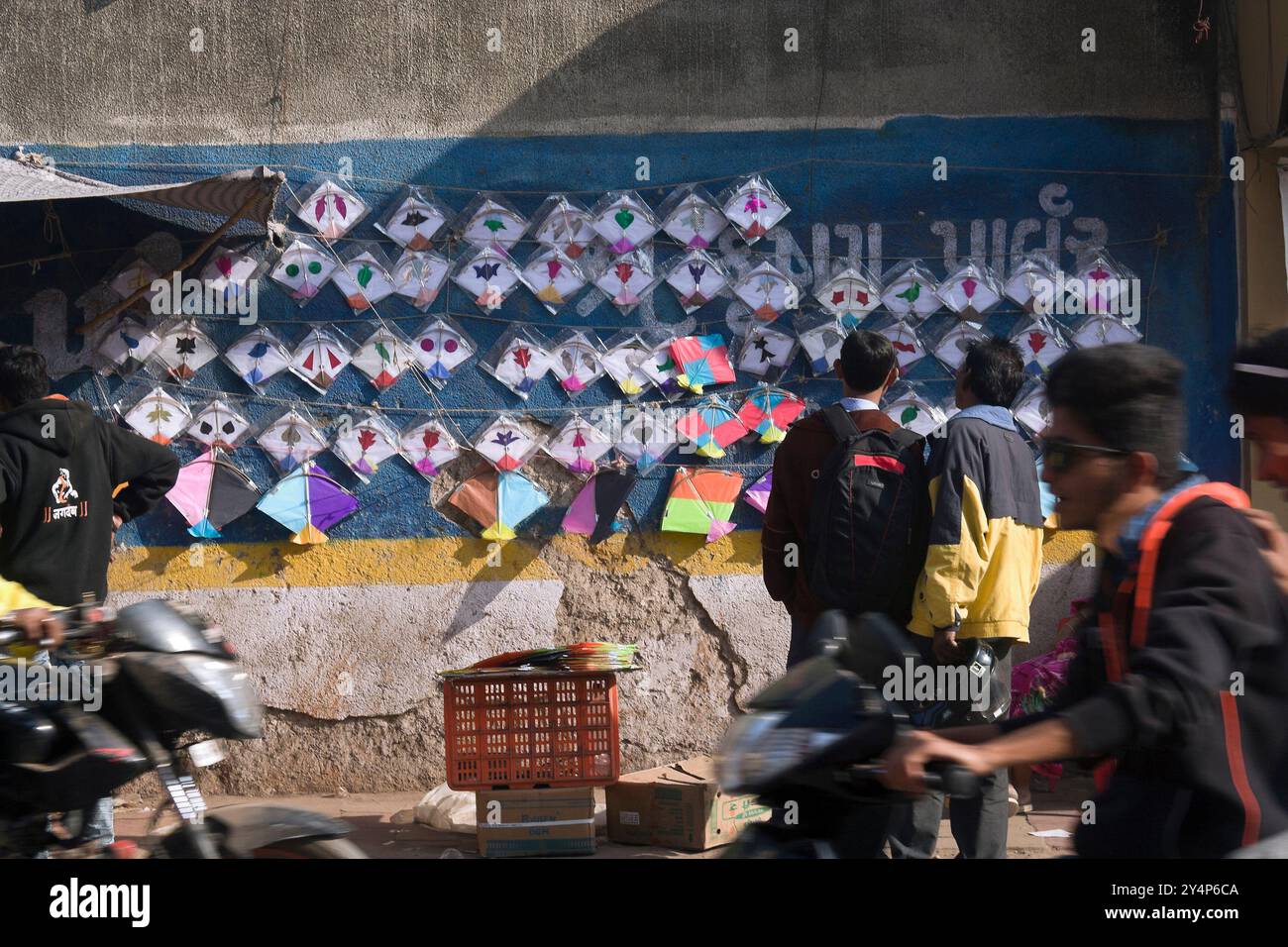 Khambhat, Gujarat / Indien - 11. Januar 2017 : in Khambhat auf dem Drachenmarkt sehen zwei Männer Drachen an der Wand hängen und denken an Bu Stockfoto