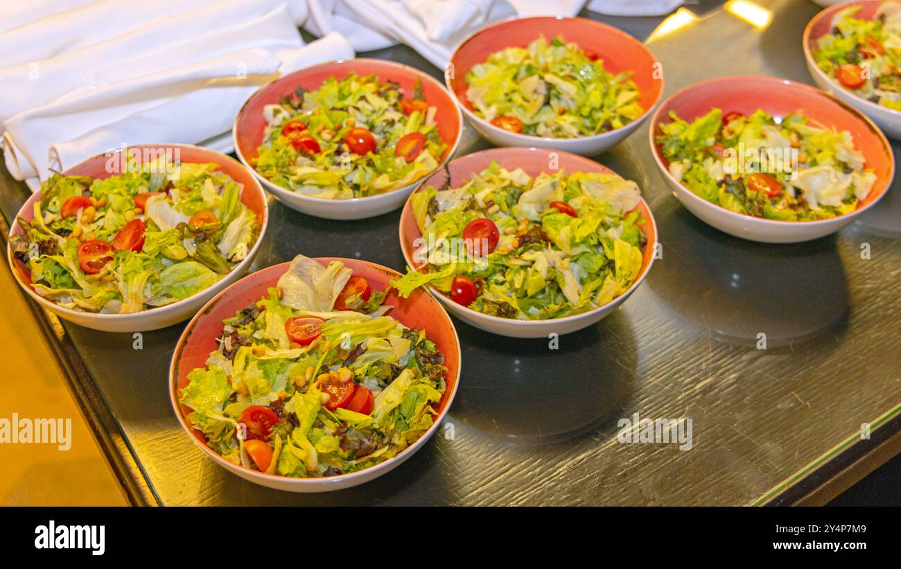 Schüsseln mit gesunden grünen Salaten werden am Buffet-Tisch serviert Stockfoto