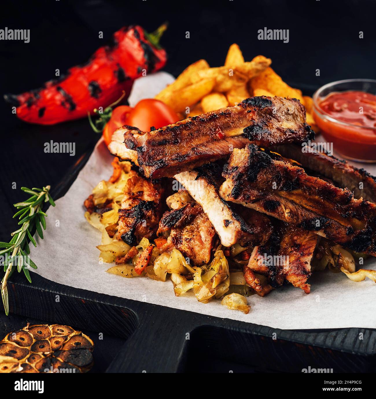 Schließen Sie das Gourmet-Hauptgericht mit gegrilltem Schweinerippchen und gebratenen Kartoffeln Stockfoto