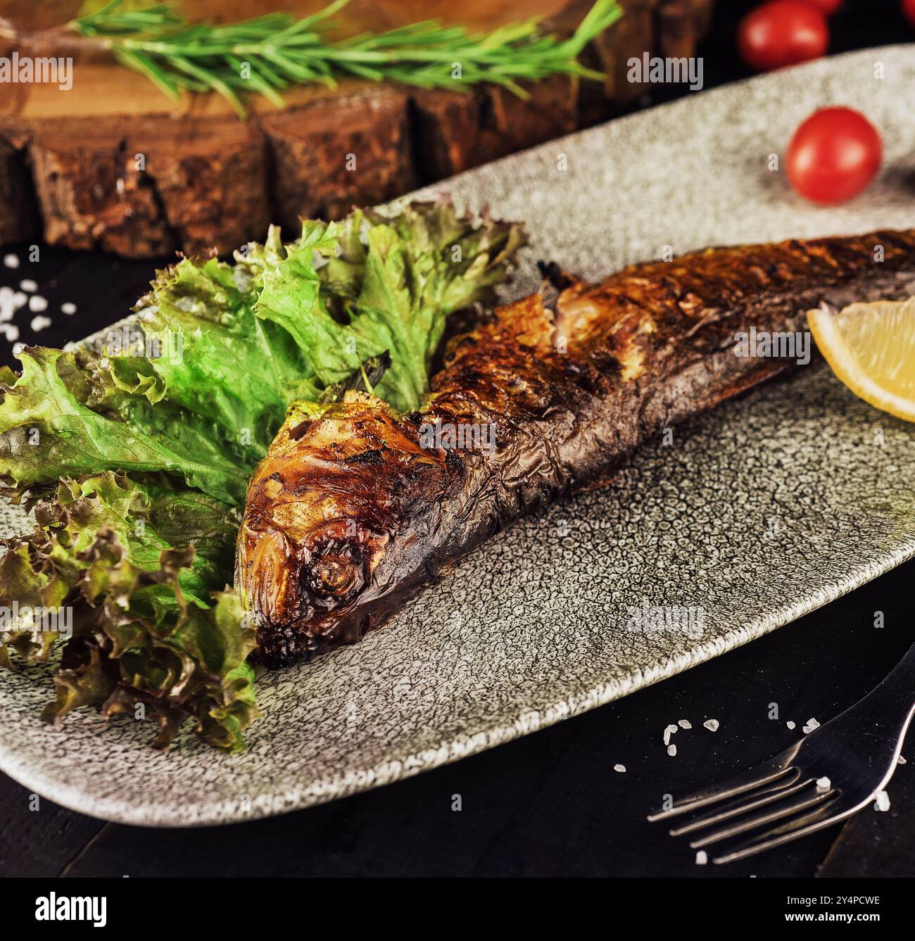 Fischgericht: Gegrillte Heringe mit Kirschtomaten Stockfoto