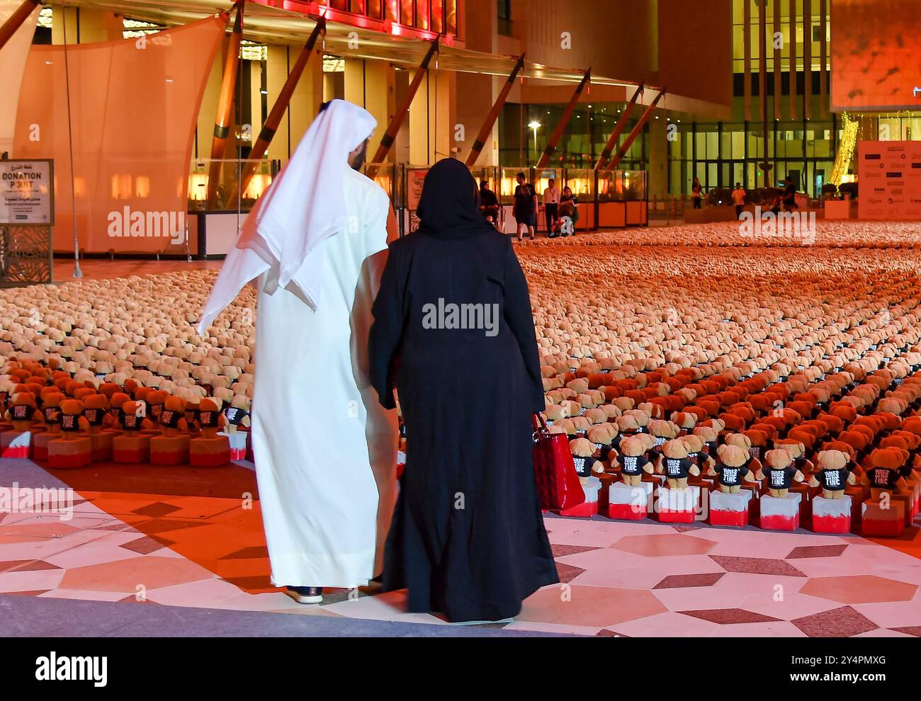 Doha, Katar. September 2024. Menschen besuchen die Installation von Teddybären mit dem Titel "Echo der verlorenen Unschuld" in der Freiluftgalerie Barahat Mashaireb, um auf palästinensische Kinder aufmerksam zu machen, die beim israelischen Angriff auf Gaza am 18. September 2024 in Doha, Katar, ums Leben gekommen sind. Die Installation mit 15.000 Teddybären wurde vom syrischen Künstler Basher Mohamad entworfen. Die Ausstellung läuft bis zum 26. September. (Foto: Noushad Thekkayil/NurPhoto) Credit: NurPhoto SRL/Alamy Live News Stockfoto