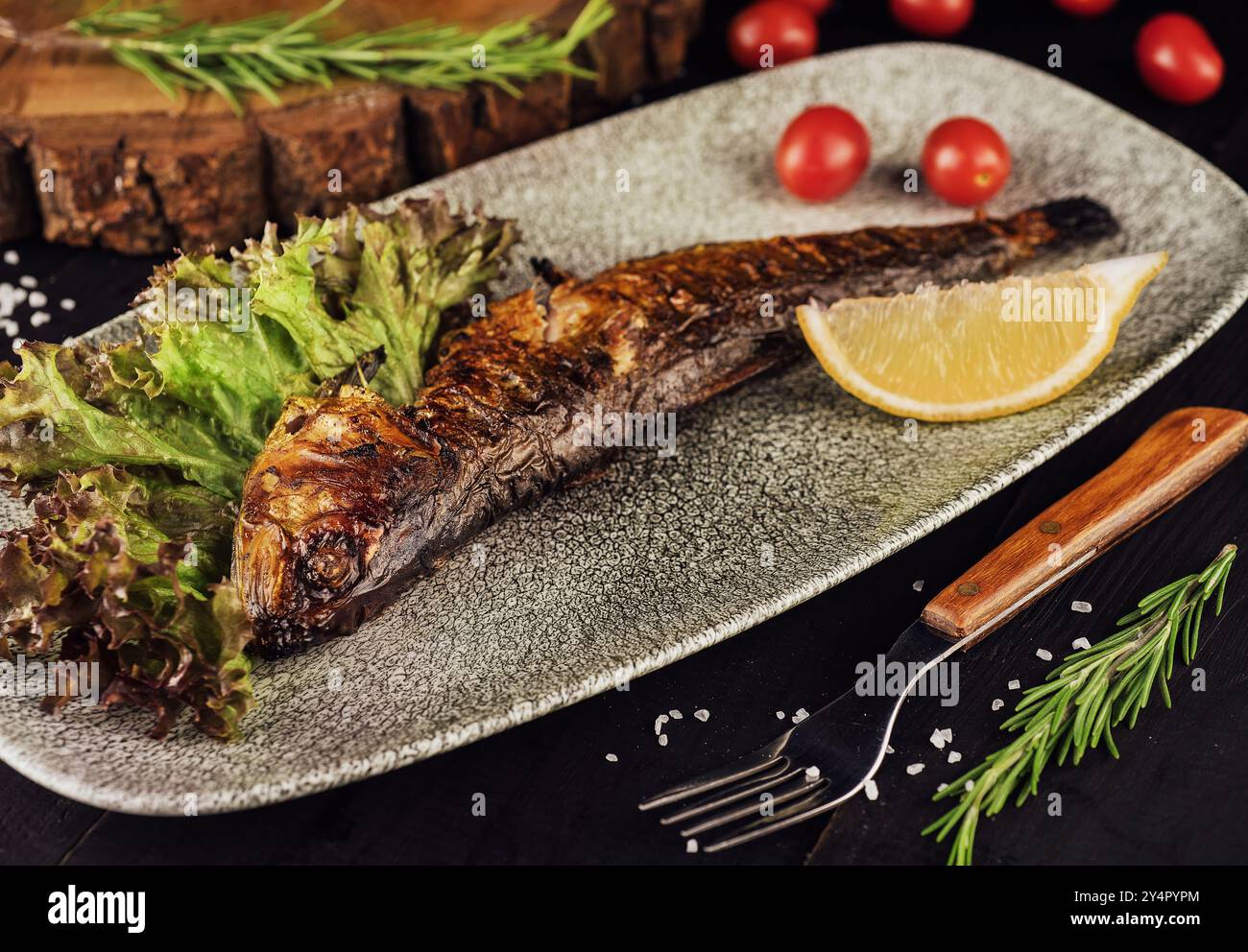 Fischgericht: Gegrillte Heringe mit Kirschtomaten Stockfoto