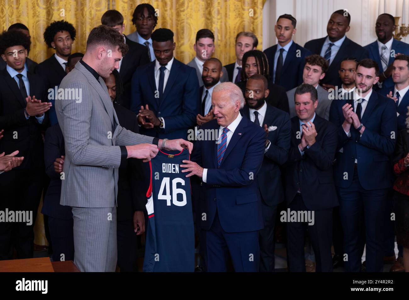 US-Präsident Joe Biden erhält ein Mannschaftstrikot vom Center Donovan Clingan während einer Feier im Weißen Haus in Washington, DC, die die NCAA-Meisterschaftssaison 2023-2024 der University of Connecticut Huskies Mens Basketball Teams feiert, 10. September 2024. Kredit: Chris Kleponis/CNP Stockfoto