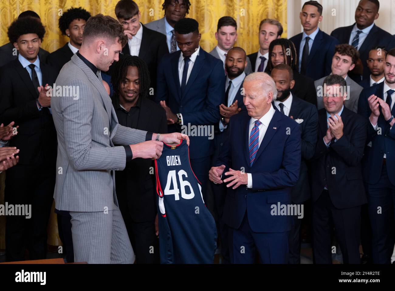 US-Präsident Joe Biden erhält ein Mannschaftstrikot vom Center Donovan Clingan während einer Feier im Weißen Haus in Washington, DC, die die NCAA-Meisterschaftssaison 2023-2024 der University of Connecticut Huskies Mens Basketball Teams feiert, 10. September 2024. Kredit: Chris Kleponis/CNP Stockfoto