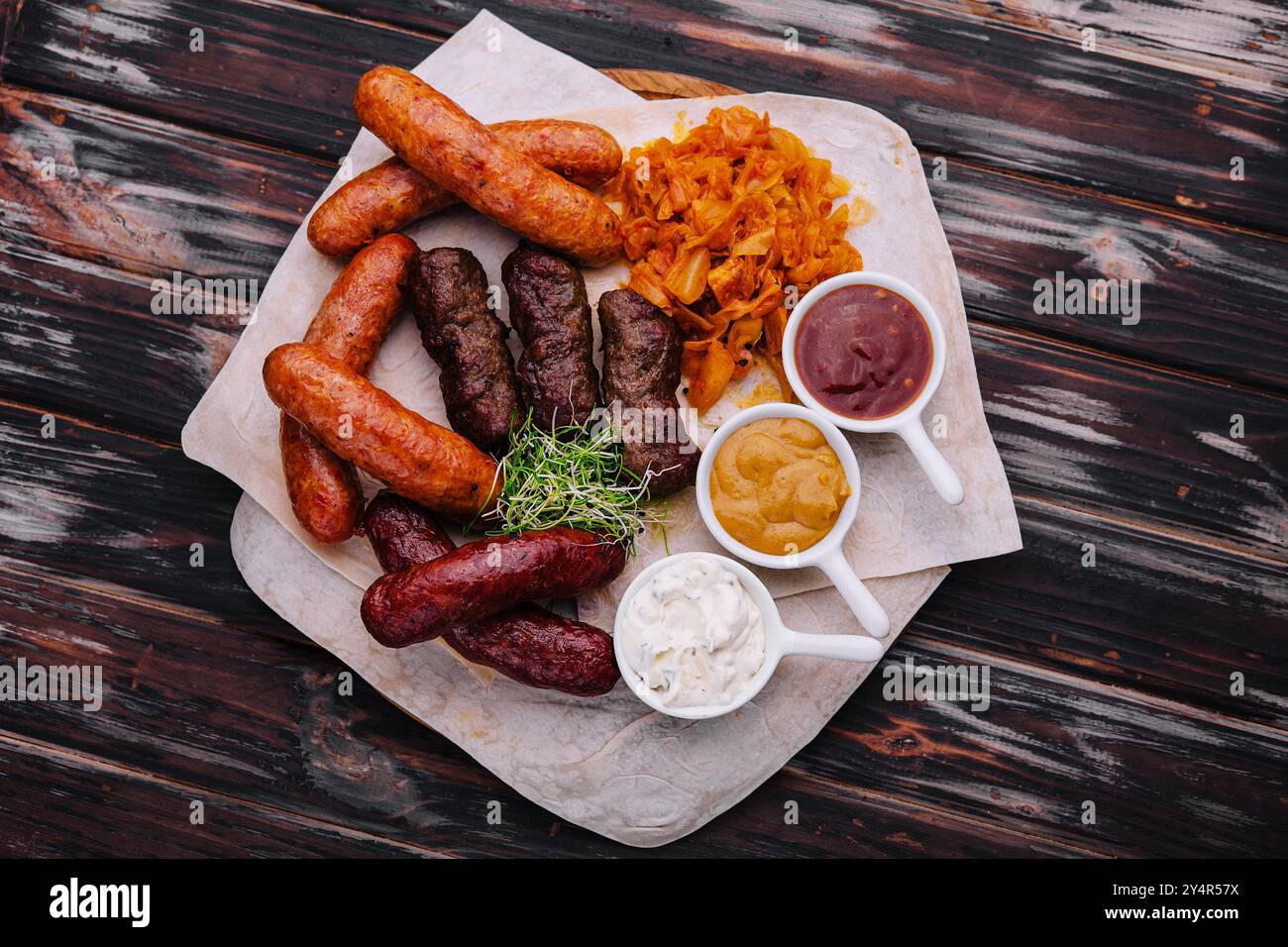 Bierset mit gegrillten Würstchen mit gedünstetem Kohl und Saucen Stockfoto