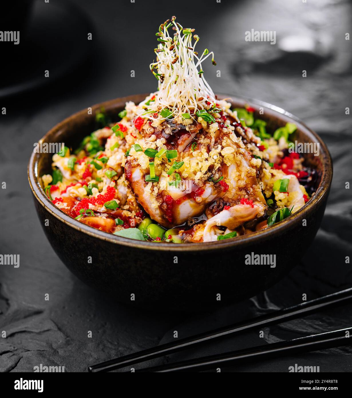 Salat mit Aal und Couscous auf schwarzer Schüssel Stockfoto