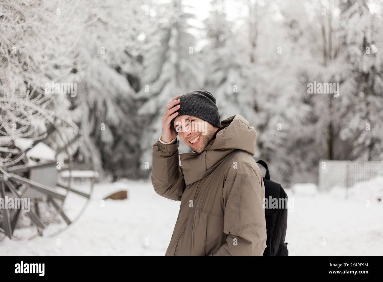 Porträt eines jungen Mannes in warmer Kleidung im Winterwald. Tourismus. Stockfoto