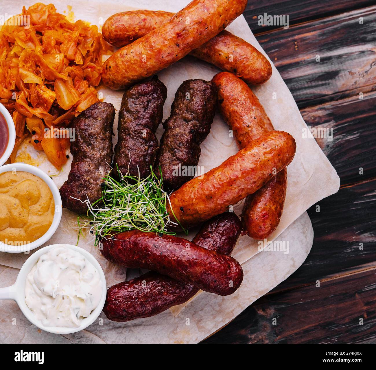 Bierset mit gegrillten Würstchen mit gedünstetem Kohl und Saucen Stockfoto