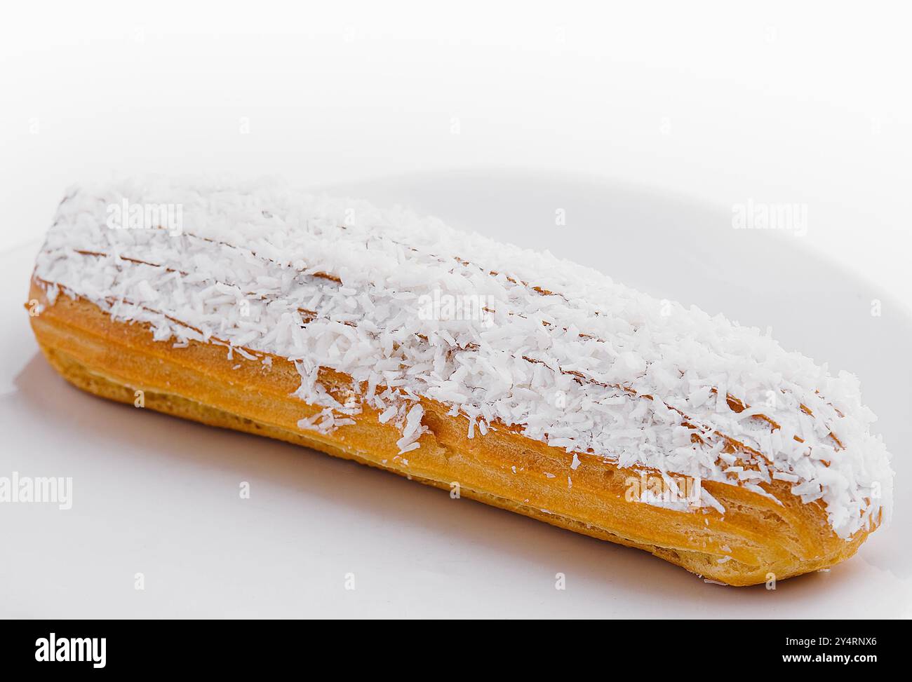 eclair in Weißglasur und Kokosflocken Stockfoto