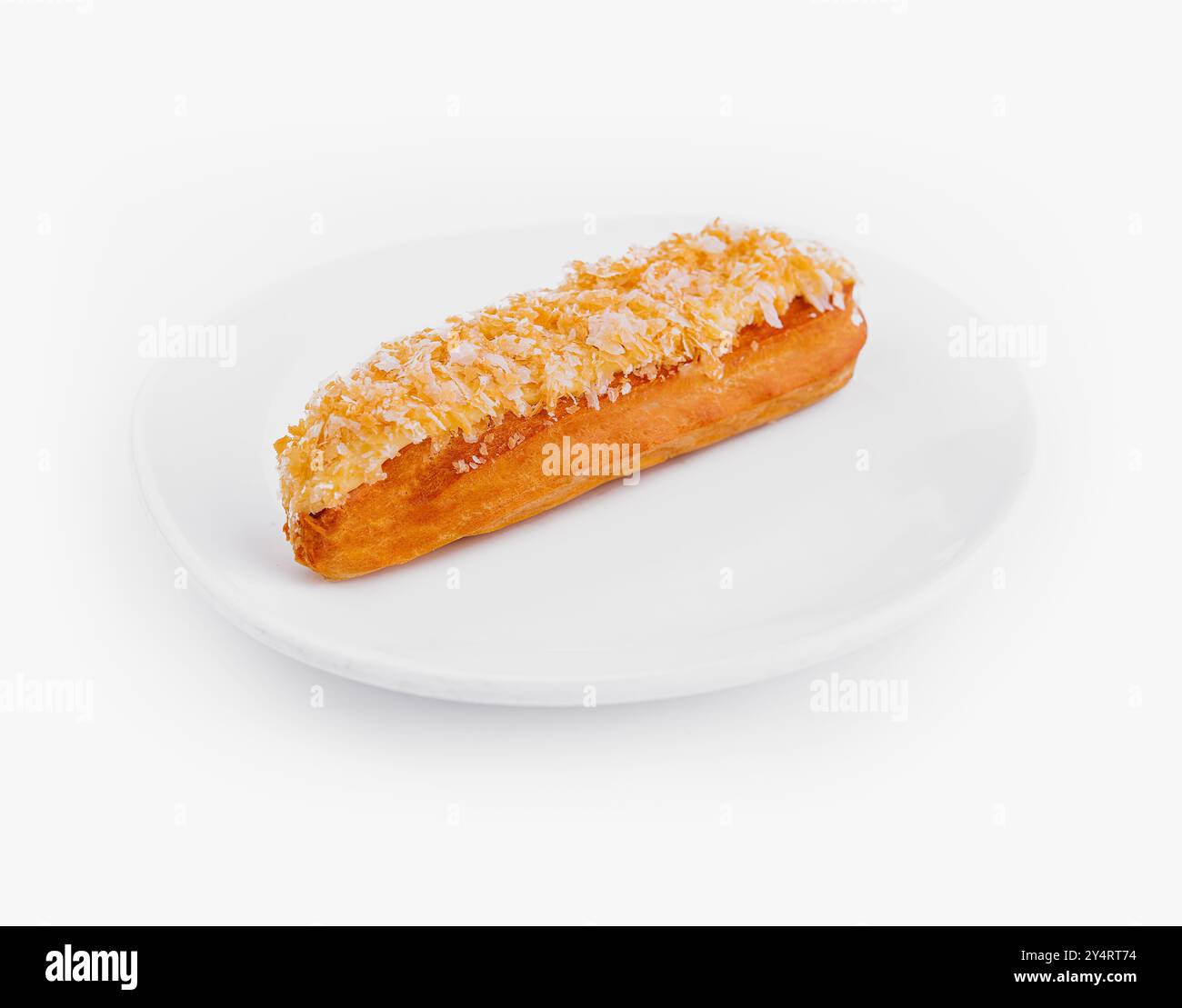 Köstliches Eclair mit Kokosnuss auf einer sauberen weißen Platte isoliert auf weißem Hintergrund Stockfoto