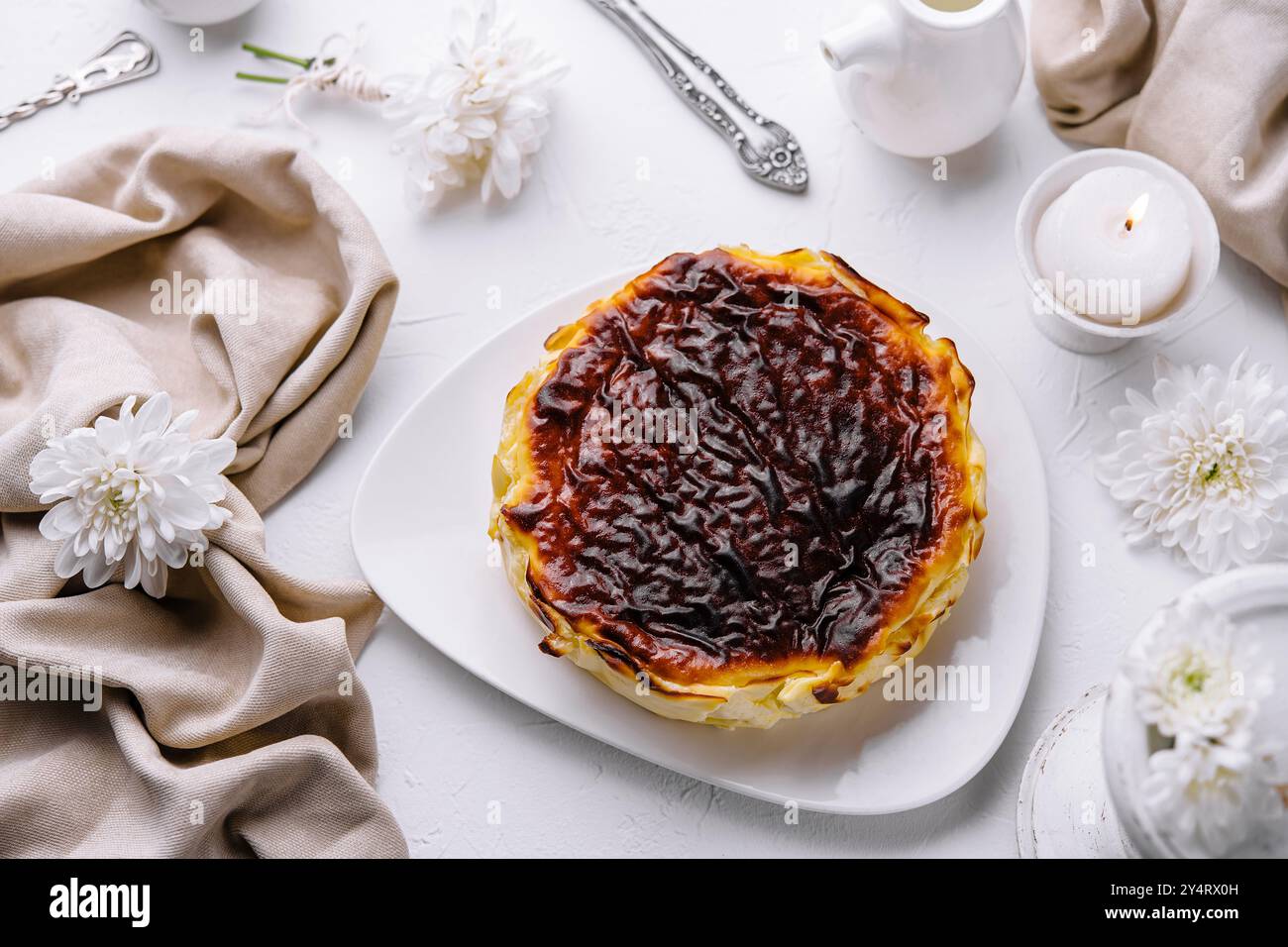 Köstliches Pastell de Nata mit karamellisierter Platte, serviert auf einem weißen Teller, umgeben von elegantem Tischdekor Stockfoto