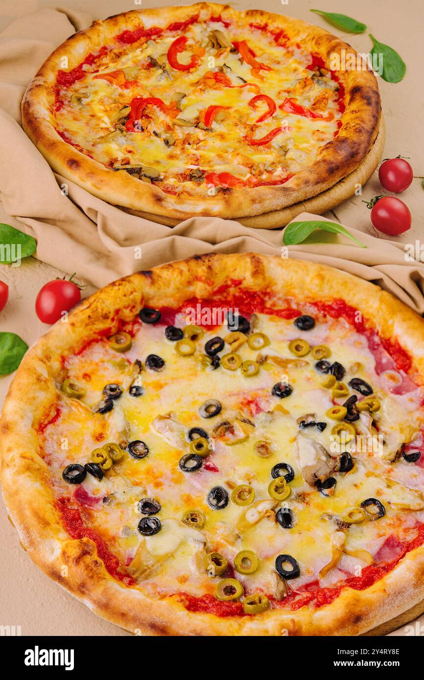 Zwei köstliche Pizzen mit herzhaften Belägen auf beigefarbenem Hintergrund Stockfoto