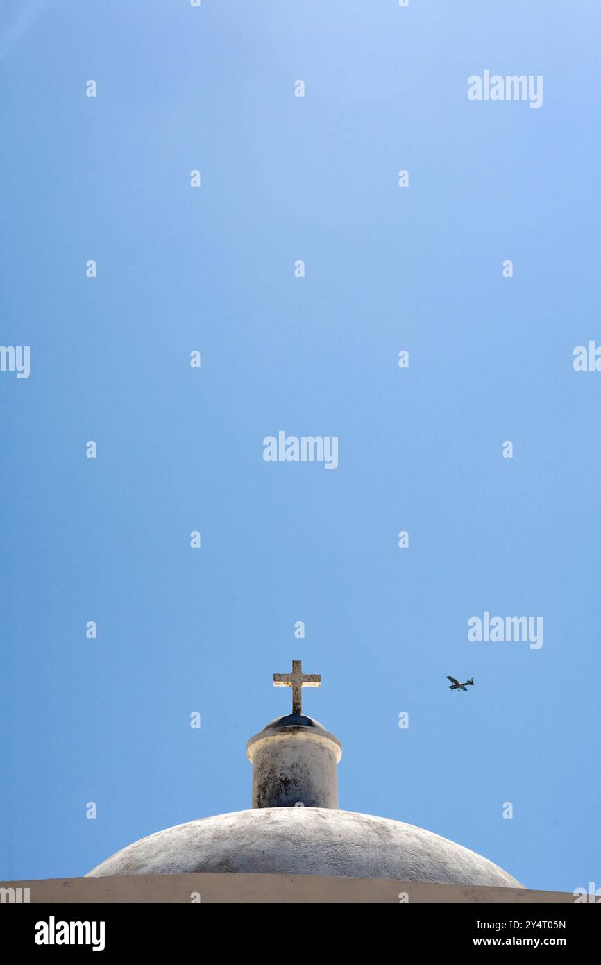 Die Kuppel von Nossa Senhora da Graca steht hoch in der Festung Sagres, eingerahmt von einem hellblauen Himmel und einem fernen Flugzeug. Stockfoto