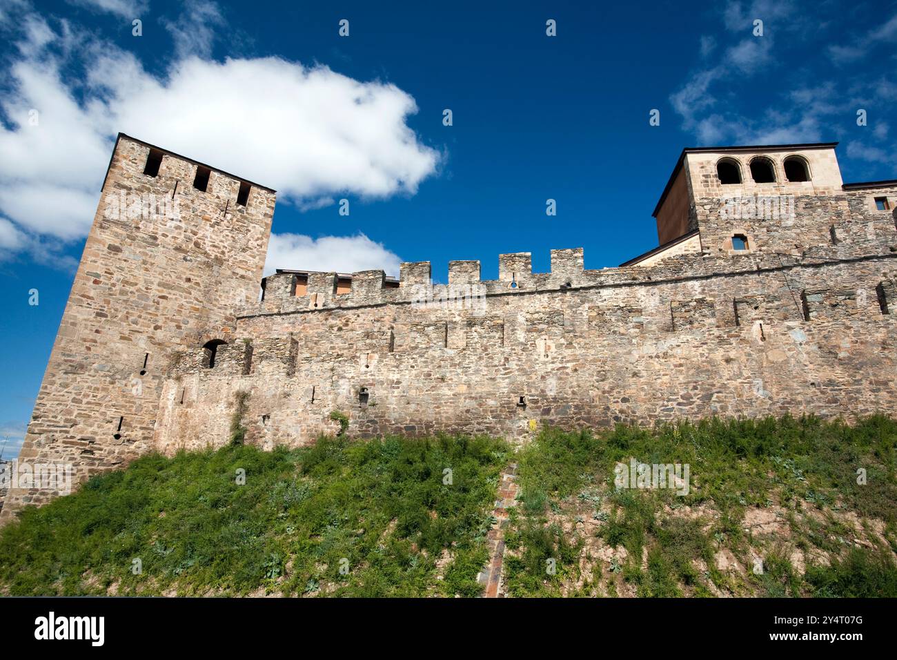 Entdecken Sie die beeindruckenden Mauern von Castillo del Temple, die mittelalterliche Architektur unter einem hellblauen Himmel in Ponferrada zeigen. Stockfoto
