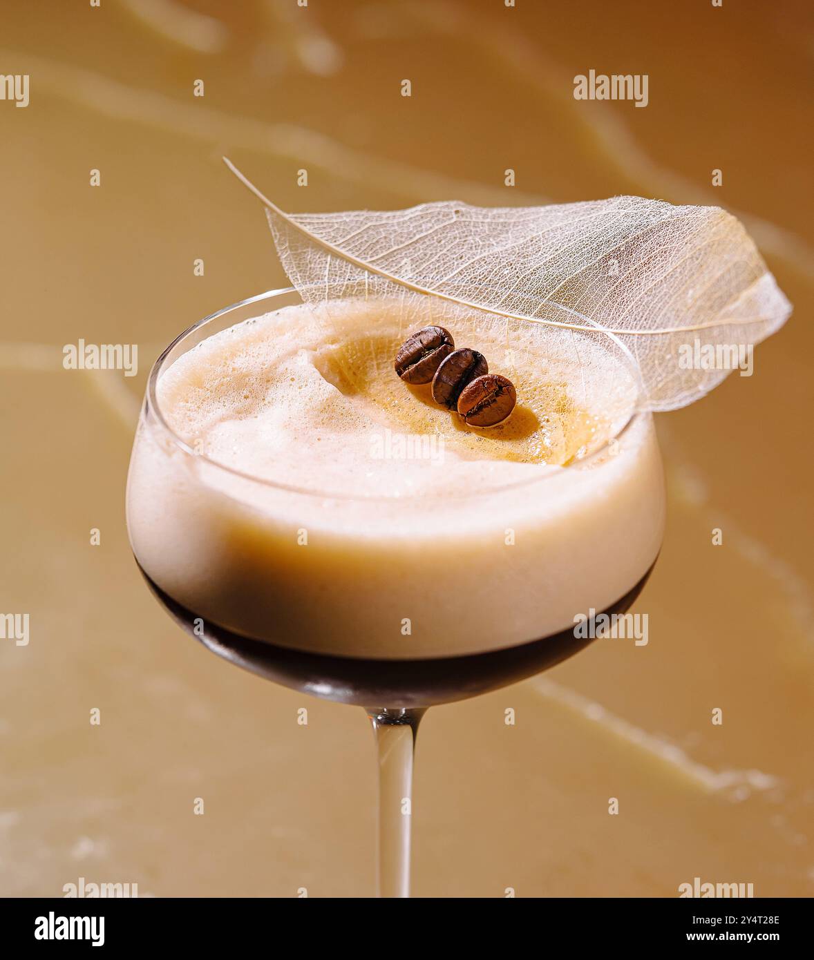 Raffinierter Espresso-Martini garniert mit Kaffeebohnen und einem zarten Blatt, serviert in einem klassischen Glas Stockfoto