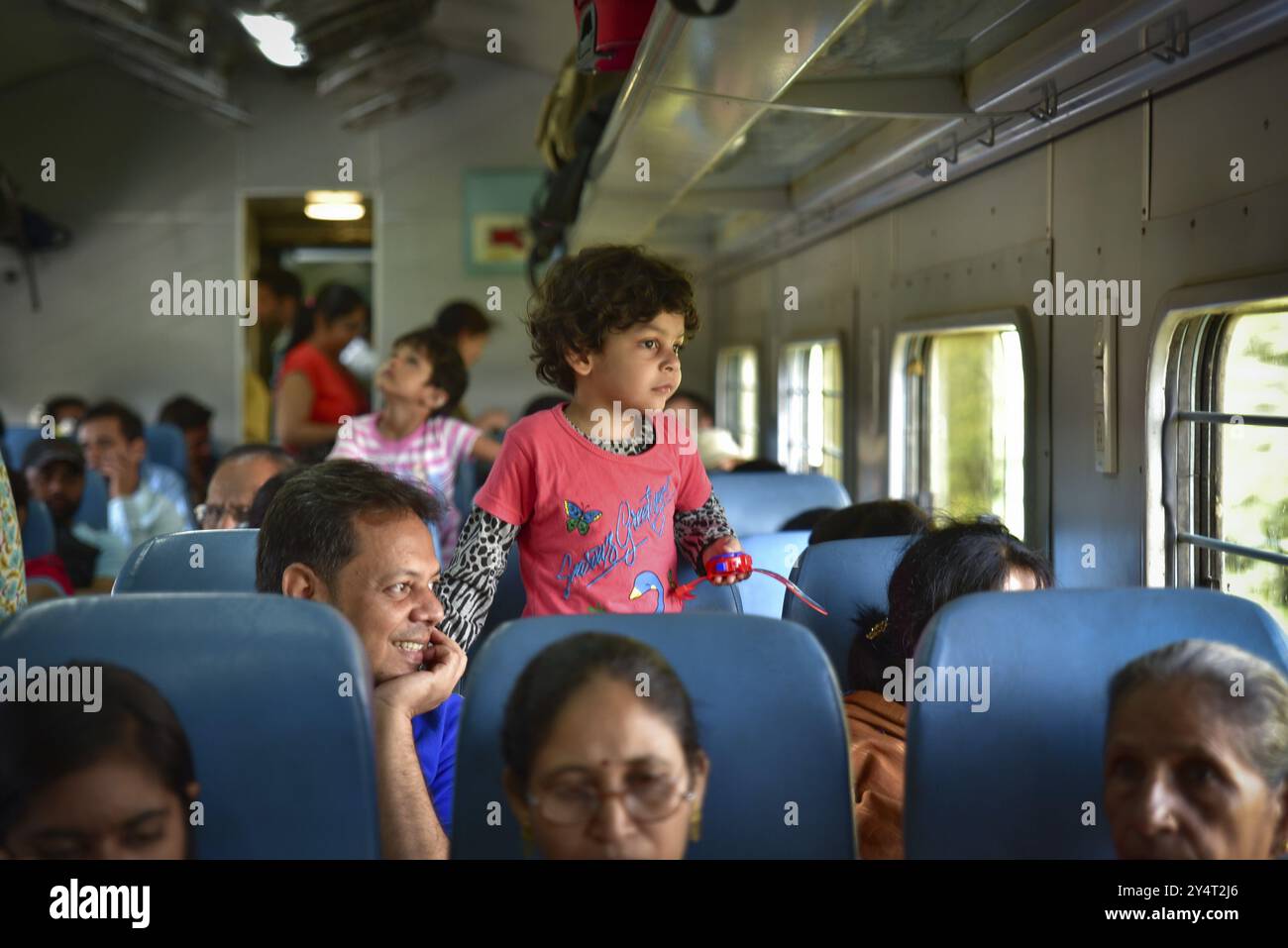 Ein Mädchen und ihr Vater im Zug blicken vor das Fenster in Indien Stockfoto