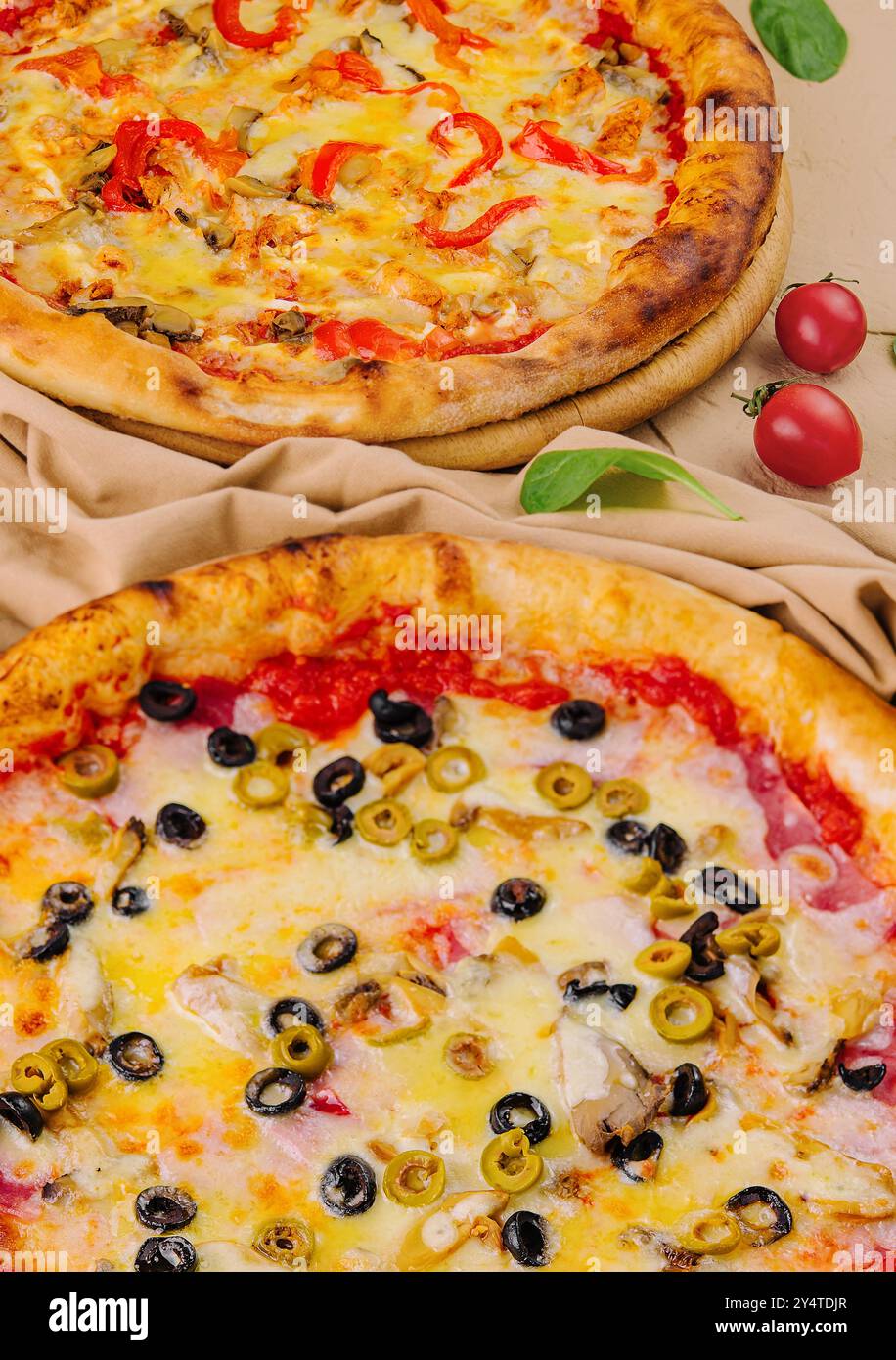 Zwei köstliche Pizzen mit herzhaften Belägen auf beigefarbenem Hintergrund Stockfoto