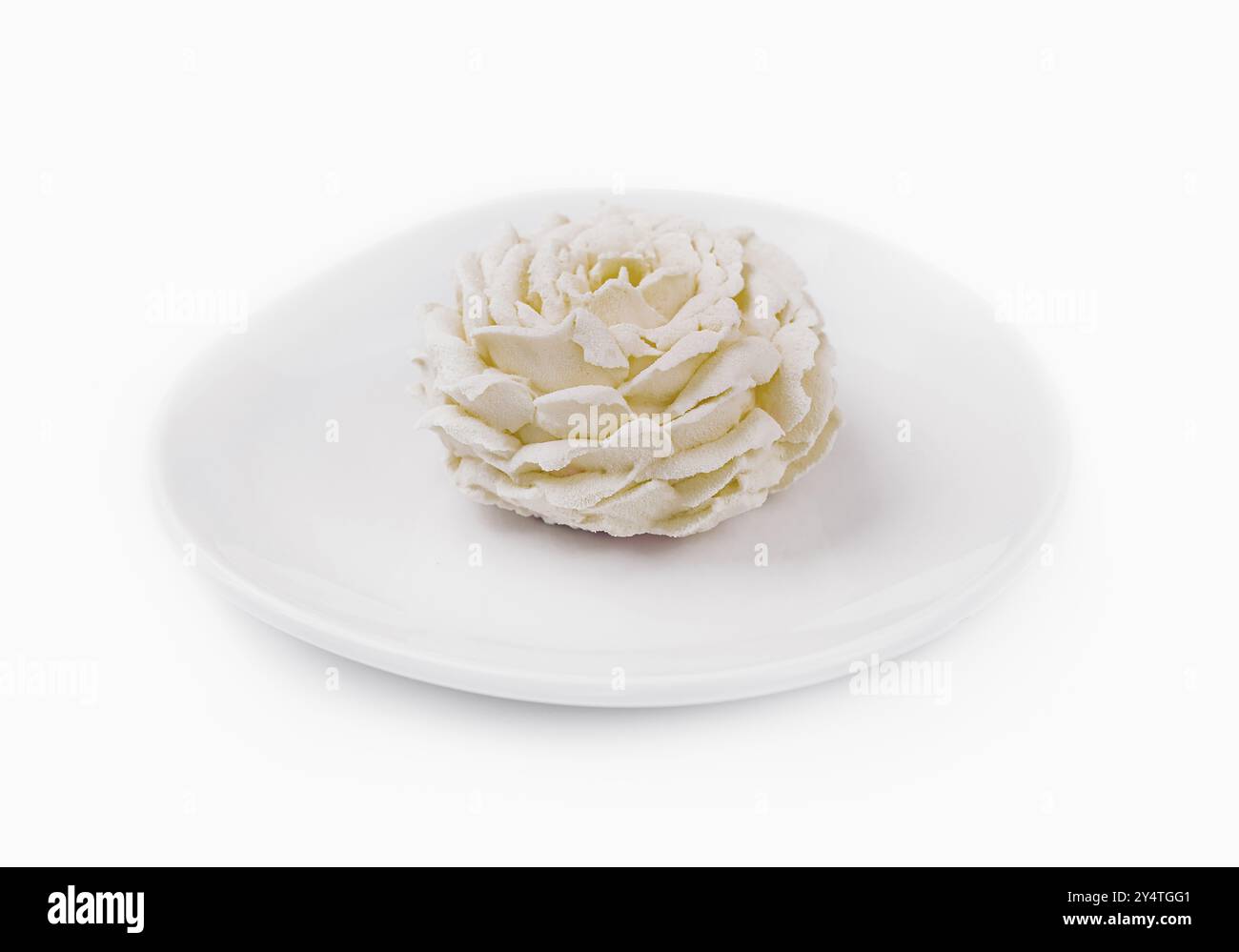 Elegante weiße essbare Blumenkuchen Dekoration auf einer sauberen Platte isoliert auf einem weißen Hintergrund Stockfoto