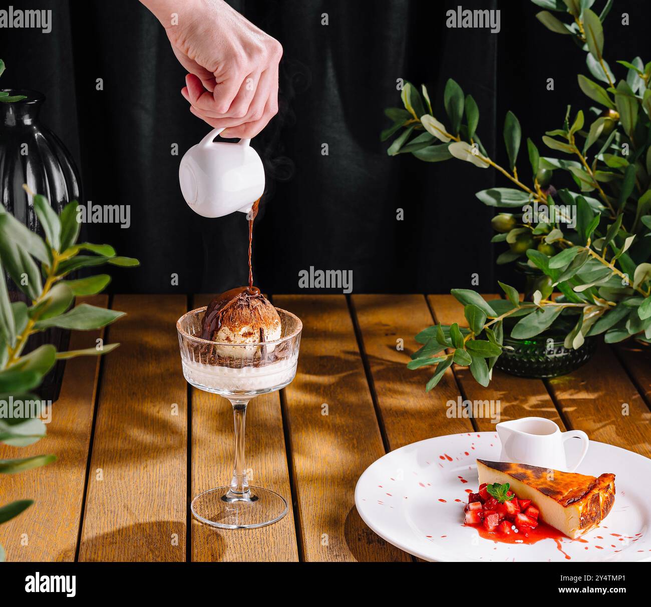 Person, die Sauce auf Eis und san sebastian Käsekuchen tränkt Stockfoto