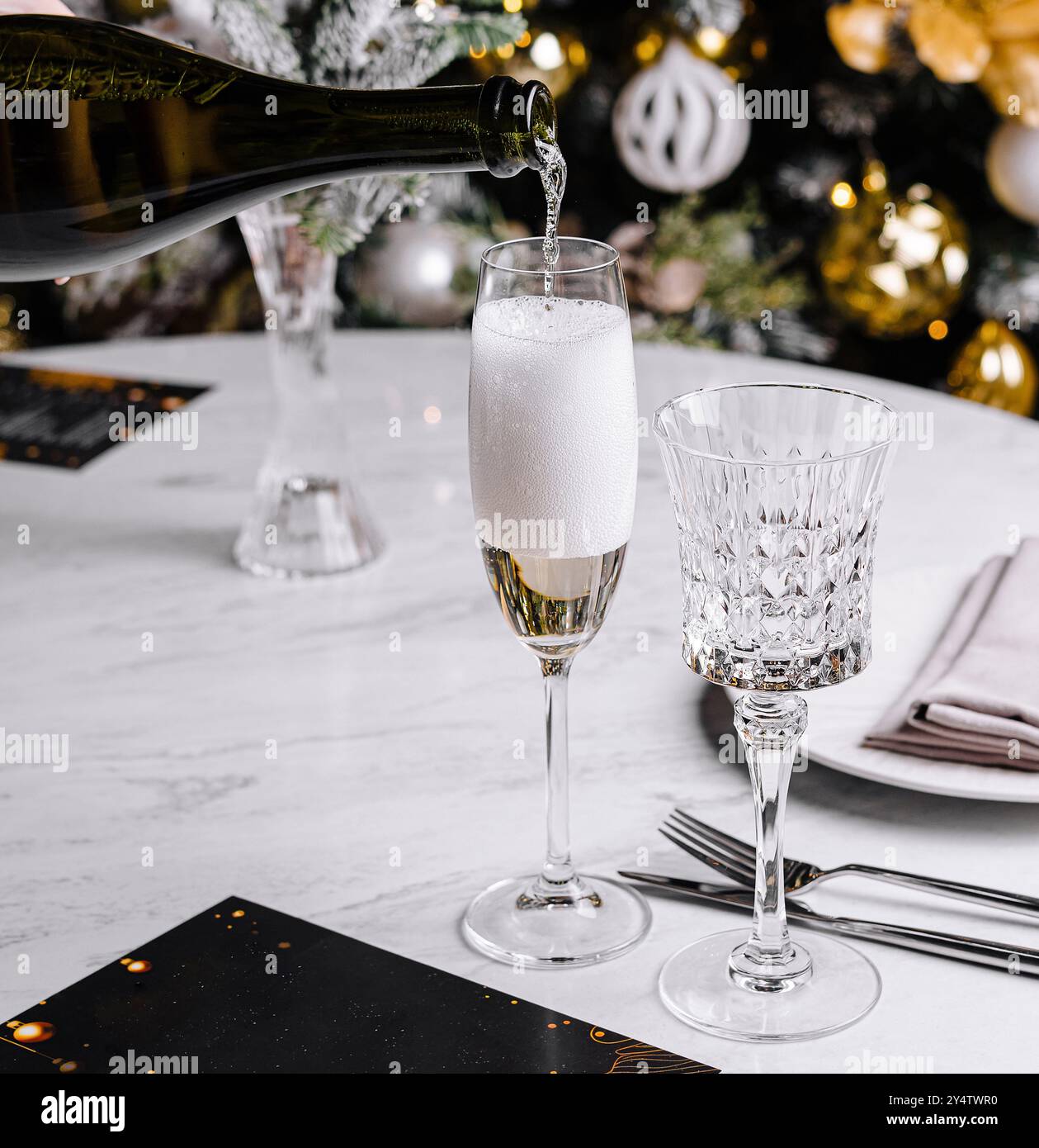 Eleganter Sekt, der in Kristallflötenglas für festliche Feierlichkeiten auf einer luxuriösen Feiertagsparty oder besonderen Anlässen gegossen wird Stockfoto